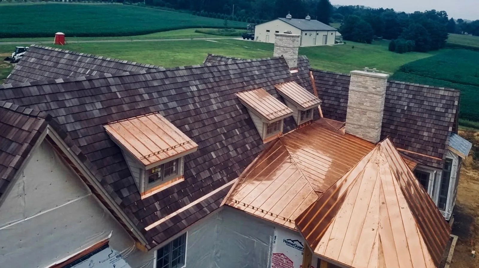 Copper standing-seam dormers on a cedar-shake estate roof by Old North Roofing